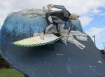 See Surfer Riding a Wave at Colac Bay, New Zealand